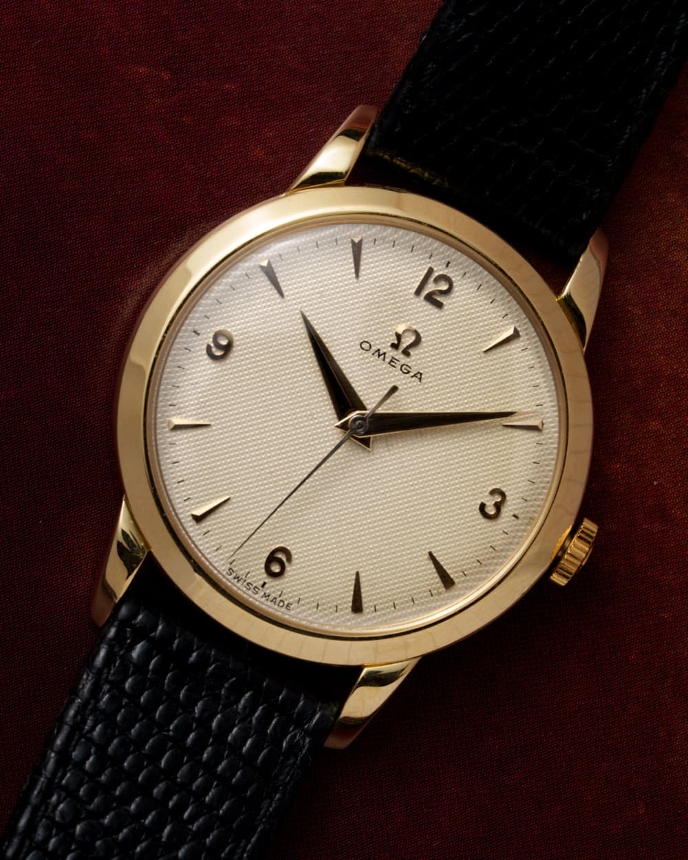 Gold Omega dress watch with honeycomb dial on a black strap